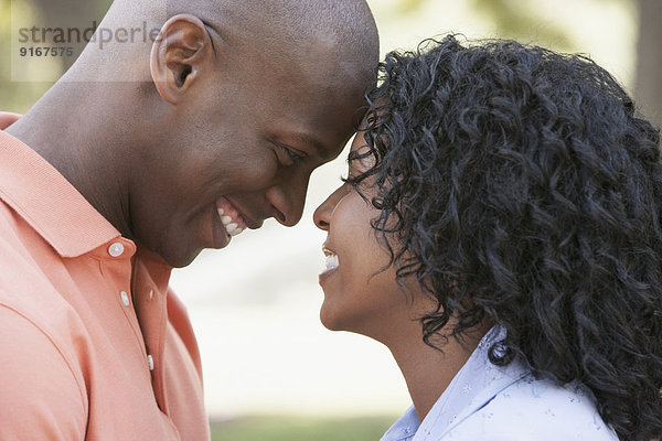 Couple touching foreheads outdoors