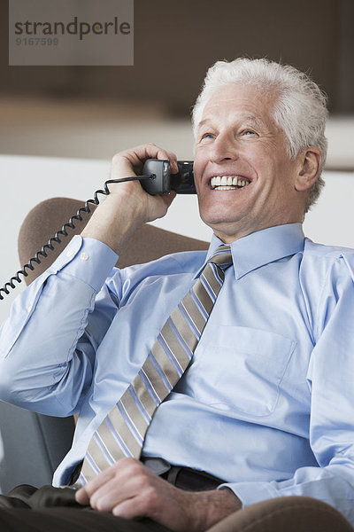 Caucasian businessman talking on telephone