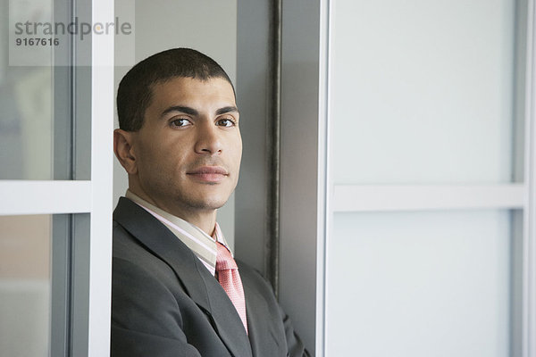 Hispanic businessman standing in doorway