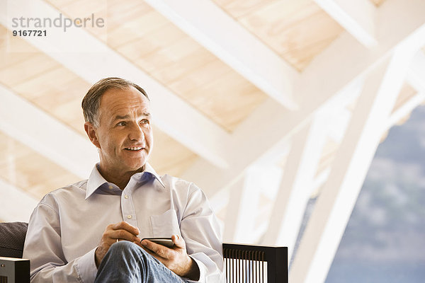 Man using cell phone in armchair