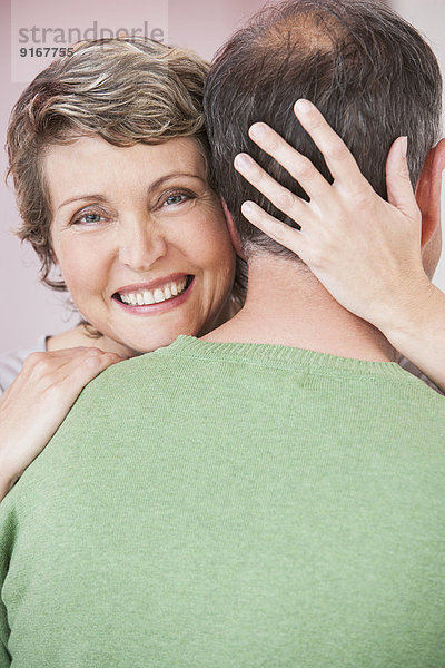 Couple hugging indoors