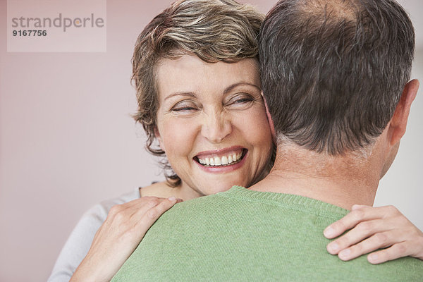 Couple hugging indoors