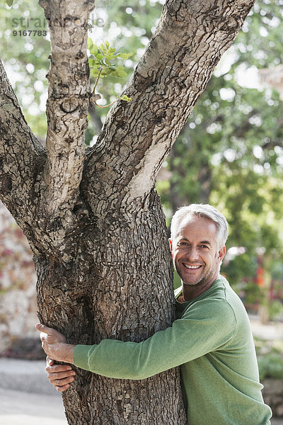 Man hugging tree outdoors