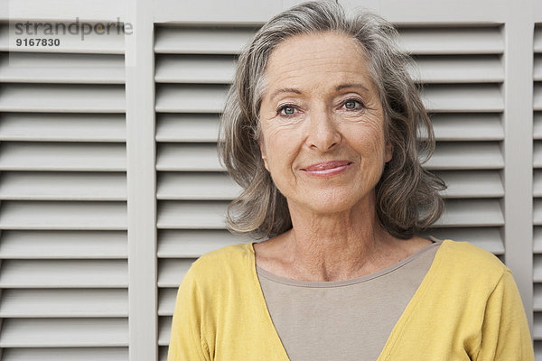 Woman smiling by shutters