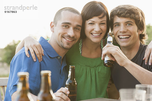 Friends drinking beer together outdoors