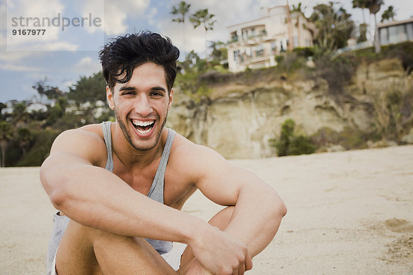 Caucasian man sitting on beach