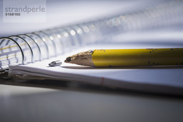 Close up of broken pencil on notebook