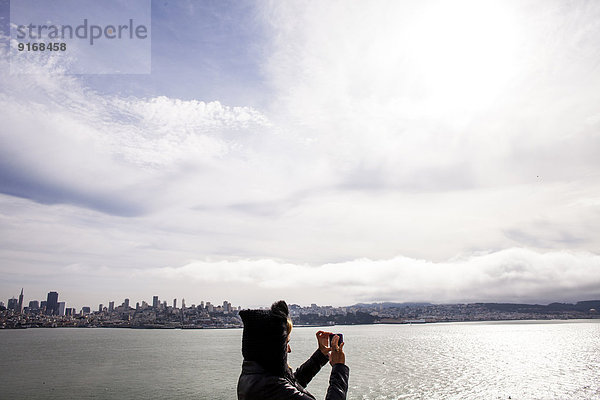 Woman taking picture of city skyline  San Francisco  California  United States