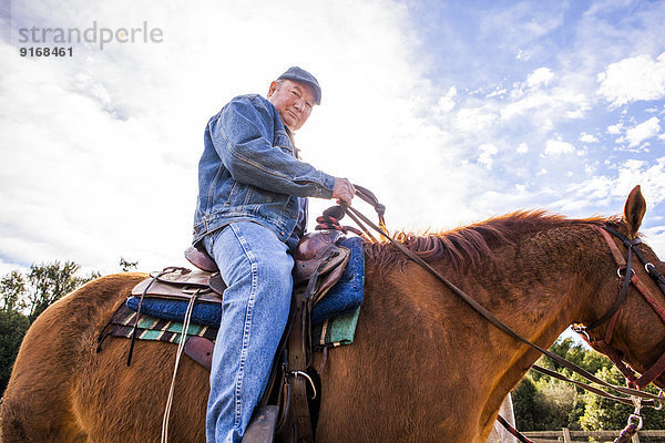 Caucasian rancher riding horse outdoors