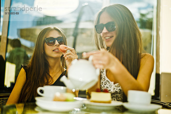 Women having coffee together at sidewalk cafe