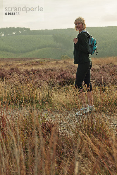 Caucasian woman hiking in rural field