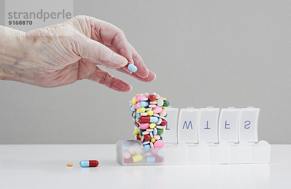 Senior Caucasian man stacking pills in pill box