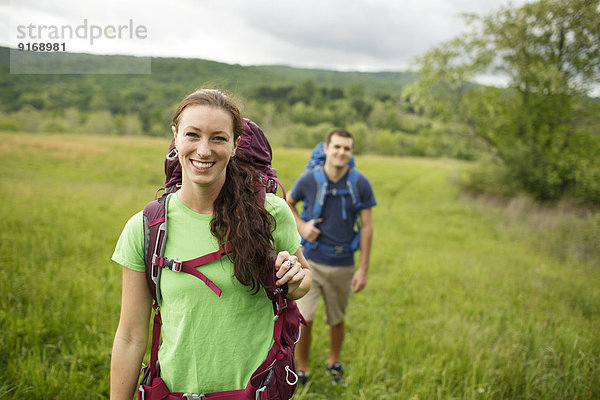 Caucasian couple hiking in rural field