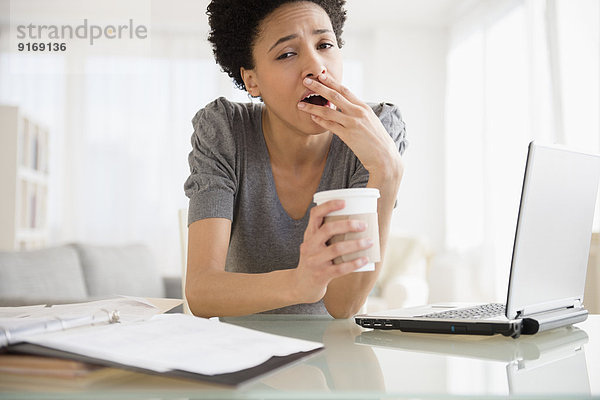 Black woman yawning at desk