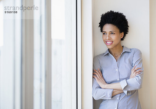 Black businesswoman smiling by window
