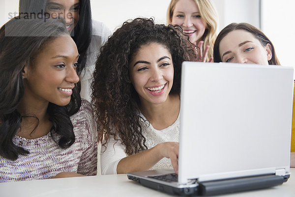 Women using laptop together