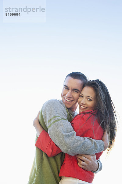 Caucasian couple hugging outdoors