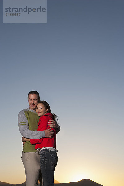 Caucasian couple hugging outdoors