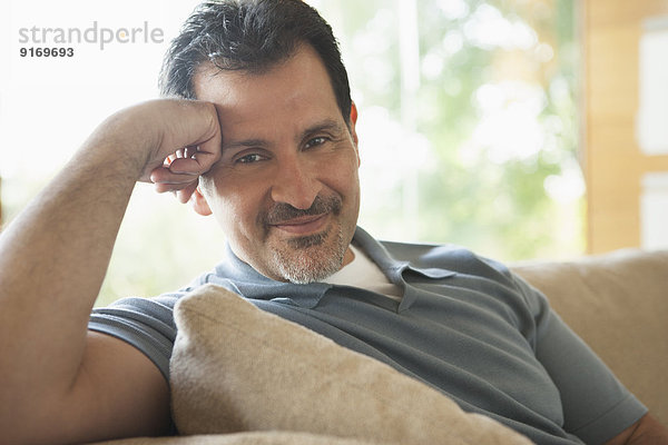 Hispanic man relaxing on sofa