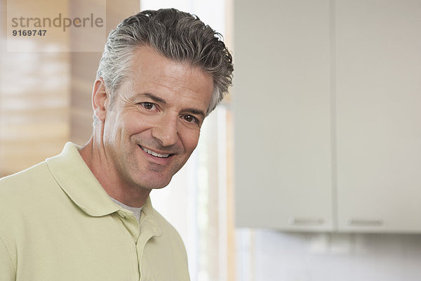 Hispanic man smiling in kitchen