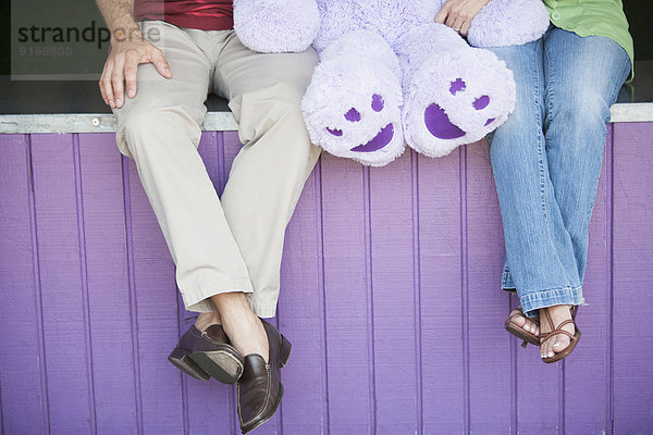 Caucasian couple with teddy bear at theme park