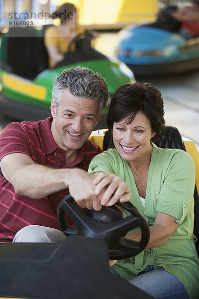 Caucasian couple driving bumper car