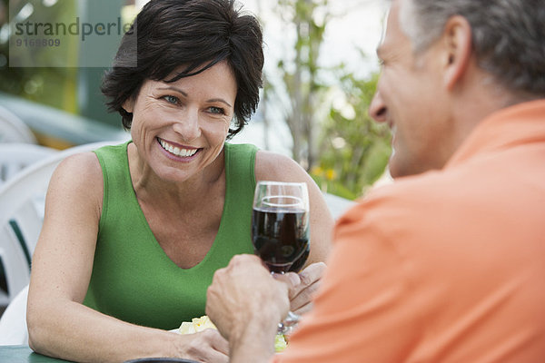 Caucasian couple toasting each other with wine