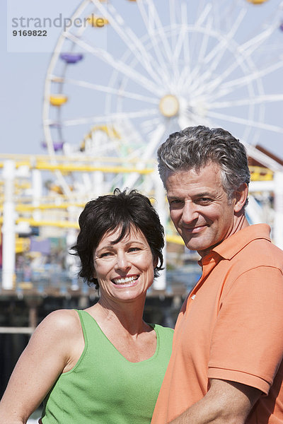 Caucasian couple hugging at theme park