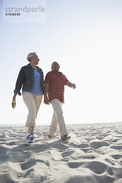 Senior African American couple walking on beach