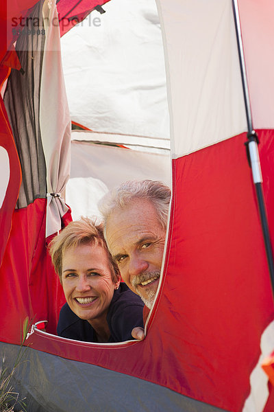 Senior Caucasian couple relaxing in tent