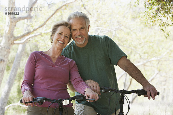 Senior Caucasian couple riding bicycles on rural path