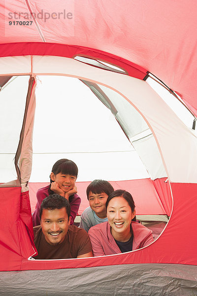 Family relaxing together in tent