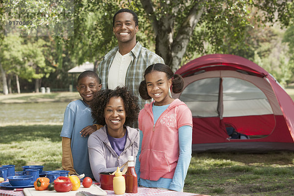 Family smiling together at campsite