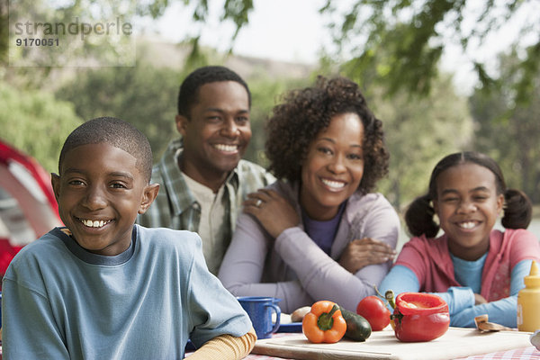 Family smiling together at campsite