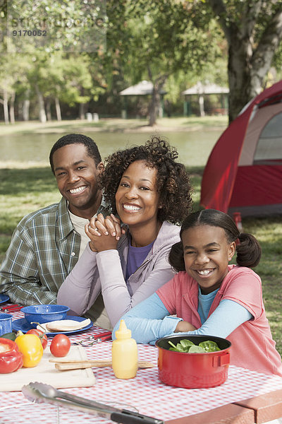 Family smiling together at campsite