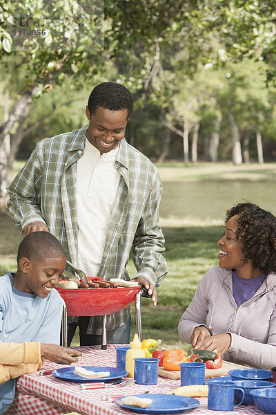 Family cooking together at picnic