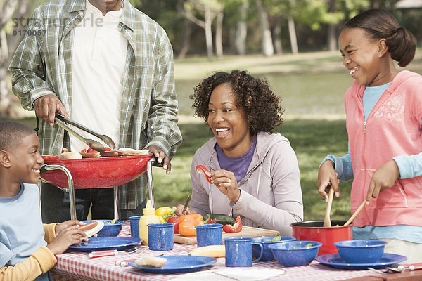 Family cooking together at picnic