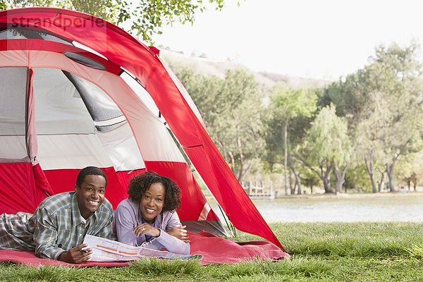 Couple reading newspaper together in tent