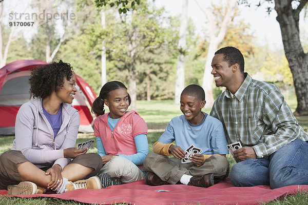 Family playing cards at campsite