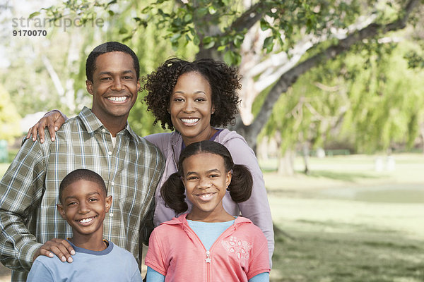 Family smiling together in park