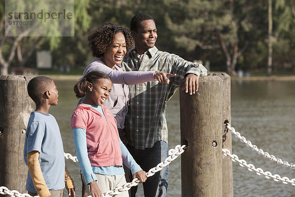 Family overlooking rural lake on dock