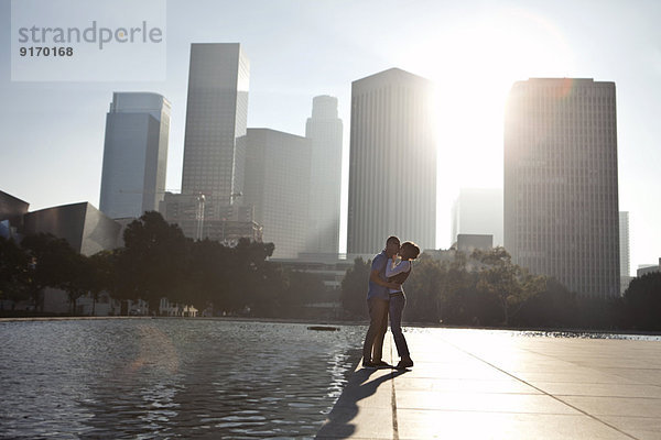 Couple kissing by urban waterfront