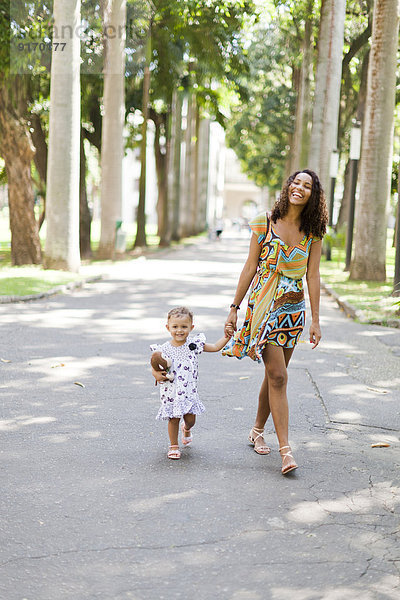 Mother and daughter walking in park