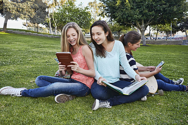 Teenage girls reading in grass