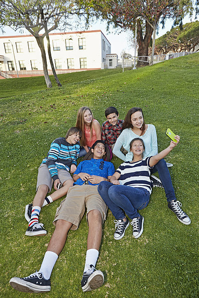 Teenagers taking picture together in grass