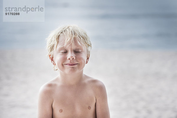 Caucasian boy smiling on beach