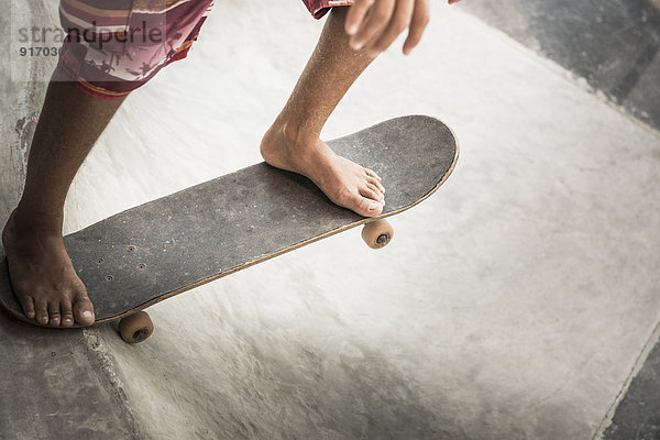 Mixed race boy riding skateboard in skate park