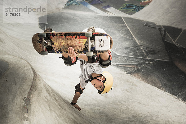 Mixed race boy riding skateboard in skate park