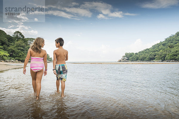 Children walking together in water