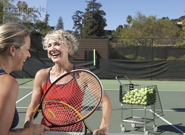 Caucasian women playing tennis on court